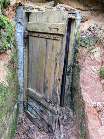 old wooden door fragments in sandstone wall cover cellars dug in sandstone rockの写真素材