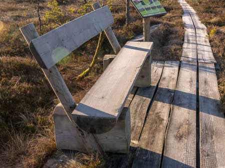 winter landscape with wooden pedestrian platform, frosted bench resting placeの写真素材