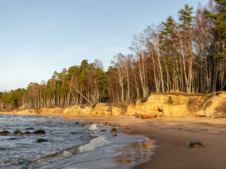 sunset landscape with sandstone cliffs, beach in the foregroundの写真素材