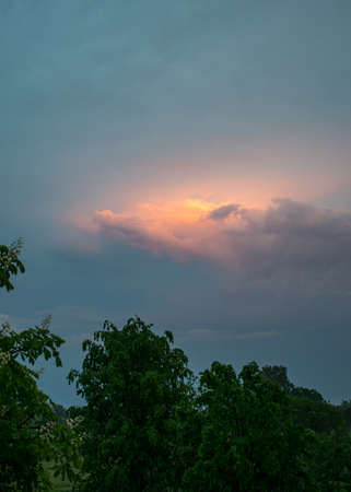 summer landscape with a colorful sunset over the roof, view through the windowの写真素材