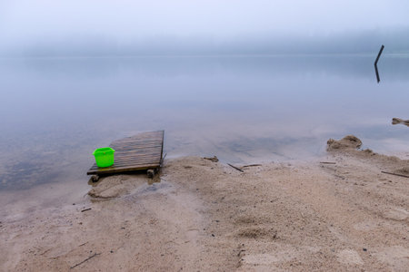 landscape with sandy beach after heavy rain, white fog on the lake, fuzzy contoursの写真素材