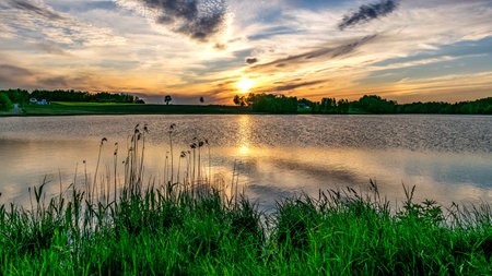 summer picture with beautiful colorful sunset over the lake, a wonderful place of strength and energy, peace, harmony and quietの写真素材
