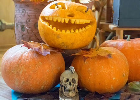 orange halloween pumpkin with carved traditional face, skull symbol, halloween decor, autumnの写真素材