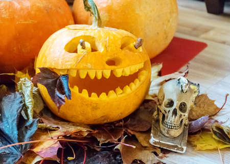 orange halloween pumpkin with carved traditional face, skull symbol, halloween decor, autumnの写真素材