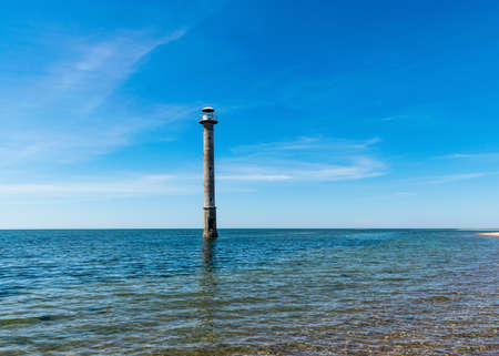 summer landscape with an abandoned sloping lighthouse "Kiipsaare lighthouse" on the Baltic Sea. Clear water and blue sky with white clouds. Harilaid Nature Reserve, Estonia, Baltic Seaの写真素材
