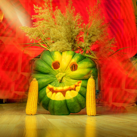 carved green pumpkin on a background of red light paintings, green Halloween Jack o Lanterns, Halloween, autumnの写真素材