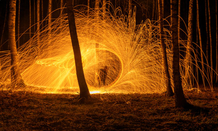 Fire circle spinning from steel wool creating spiral spark, Steel wool spinning fire circle spinning from steel wool creating spiral spark, birch groveの写真素材