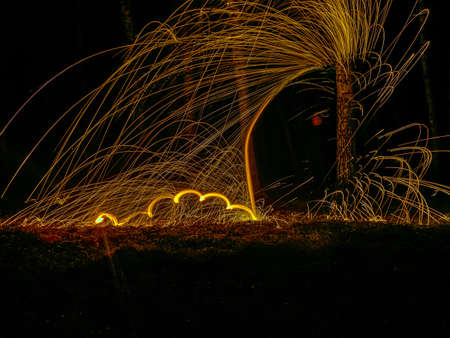 Fire circle spinning from steel wool creating spiral spark, Steel wool spinning fire circle spinning from steel wool creating spiral spark, birch groveの写真素材