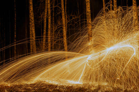 Fire circle spinning from steel wool creating spiral spark, Steel wool spinning fire circle spinning from steel wool creating spiral spark, birch groveの写真素材