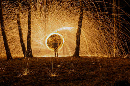 Fire circle spinning from steel wool creating spiral spark, Steel wool spinning fire circle spinning from steel wool creating spiral spark, birch groveの写真素材