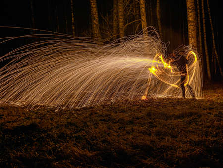 Fire circle spinning from steel wool creating spiral spark, Steel wool spinning fire circle spinning from steel wool creating spiral spark, birch groveの写真素材
