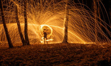 Fire circle spinning from steel wool creating spiral spark, Steel wool spinning fire circle spinning from steel wool creating spiral spark, birch groveの写真素材