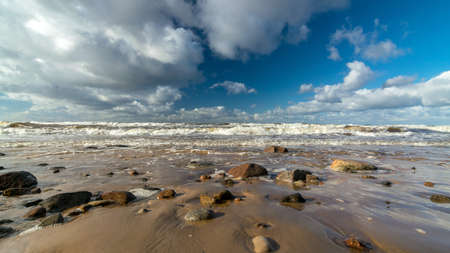 beautiful seascape with sea waves crashing on the shore and exploding, beautiful blue skies and white clouds over the sea, Vidzeme rocky seashore, Salacgriva rural area, Latviaの写真素材