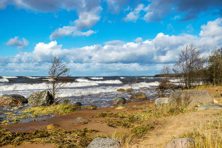 beautiful seascape with sea waves crashing on the shore and exploding, beautiful blue skies and white clouds over the sea, Vidzeme rocky seashore, Salacgriva rural area, Latviaの写真素材