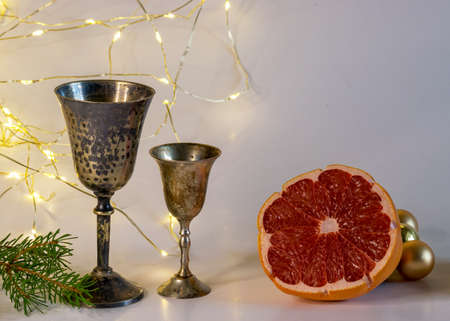 golden cups, golden glass balls and various Christmas decorations, illuminated background of a chain of white lights, Christmas timeの写真素材