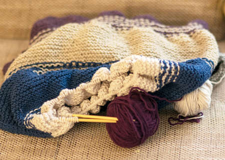 striped knitted colorful sweater with knitting needles and wool yarn, handicrafts as a hobby, hand knittingの写真素材