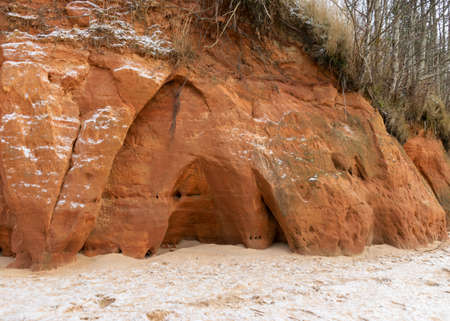 Sea cliff with Devonian sandstone outcrops. During the storm, niches and caves were washed away in the sandstones, sandstone columns were formed, Ezurgu cliffs in Salacgriva region, Liepupe parish, Latviaの写真素材