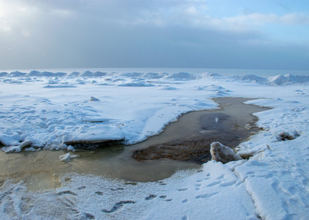 winter landscape by the sea, snowy, interesting ice shapes on the sea shore, dunes covered with a white layer of shining snow, winterの写真素材
