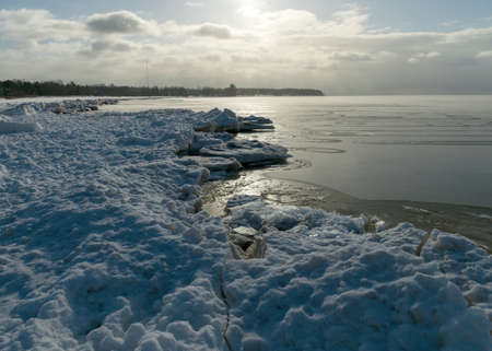 winter landscape by the sea, snowy pieces of ice by the sea and ice texture at sea, dunes covered with a layer of white snowの写真素材
