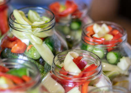 glass jars with different colors, types, shapes of vegetables, vegetables prepared for home canning,...