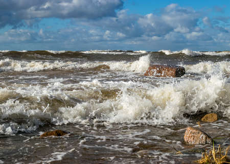 Seascape, sea wave hits stones and explodes, waves and splashes on the shore, dramatic natural background. Vidzeme's rocky seashore, Salacgriva rural area, Latviaの写真素材