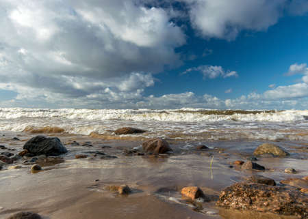beautiful seascape with sea waves crashing on the shore and exploding, beautiful blue skies and white clouds over the sea, Vidzeme rocky seashore, Salacgriva rural area, Latviaの写真素材