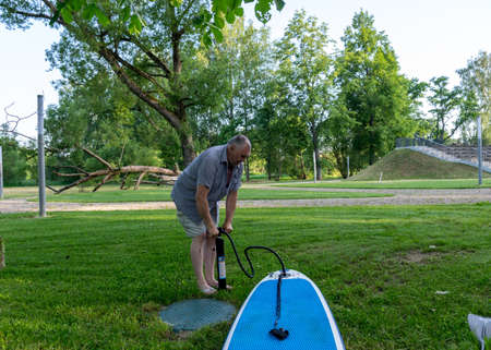 green summer landscape, a man pumps a blue padlle  boardの写真素材
