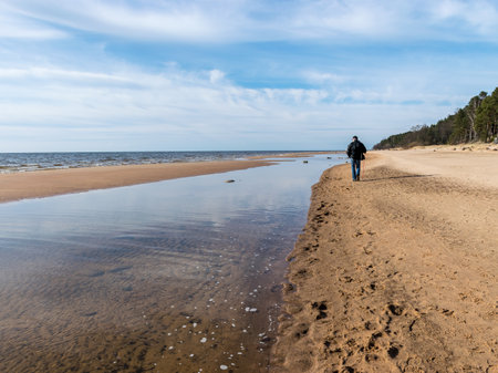 beautiful landscape with the sea shore, a man walks by the sea, beautiful blue sky and calm seaの写真素材