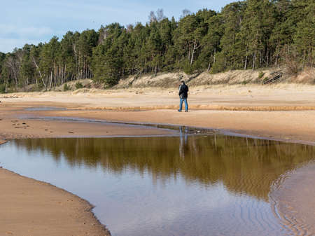 beautiful landscape with the sea shore, a man walks by the sea, beautiful blue sky and calm seaの写真素材