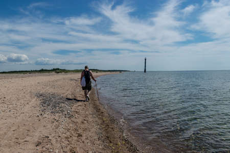 beautiful landscape with the sea shore, a man walks by the sea, beautiful blue sky and calm seaの写真素材