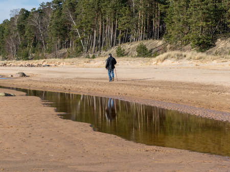 beautiful landscape with the sea shore, a man walks by the sea, beautiful blue sky and calm seaの写真素材
