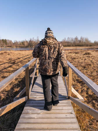male figure on wooden footbridge, bog backgroundの写真素材