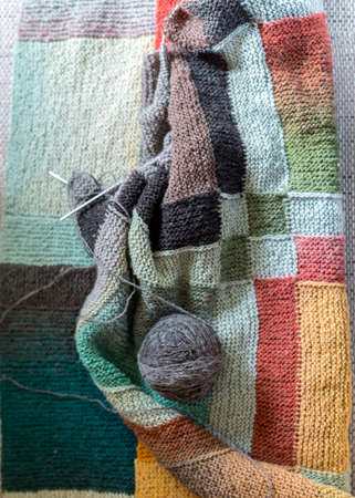 beautiful knitted wool scarf with a ball of wool yarn and wooden knitting needles, knitted background and texture, handmade, knitting pattern backgroundの写真素材