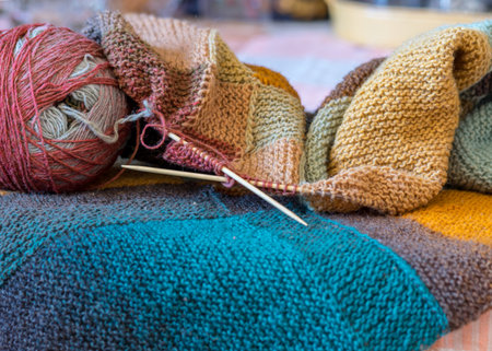 beautiful knitted wool scarf with a ball of wool yarn and wooden knitting needles, knitted background and texture, handmade, knitting pattern backgroundの写真素材