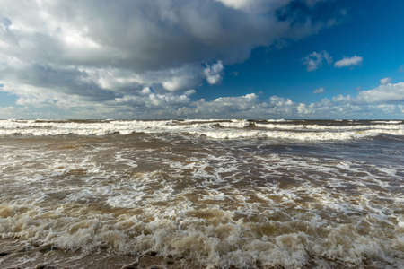 beautiful seascape with sea waves crashing on the shore and exploding, beautiful blue skies and white clouds over the sea, Vidzeme rocky seashore, Salacgriva rural area, Latviaの写真素材