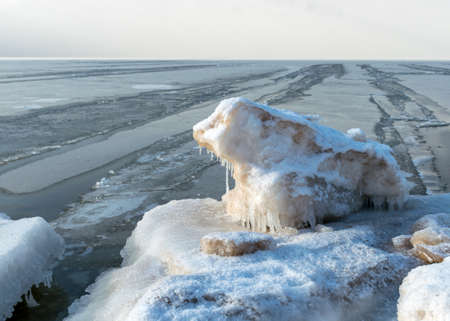 winter landscape by the sea, snowy pieces of ice by the sea and ice texture at sea, dunes covered with a layer of white snowの写真素材