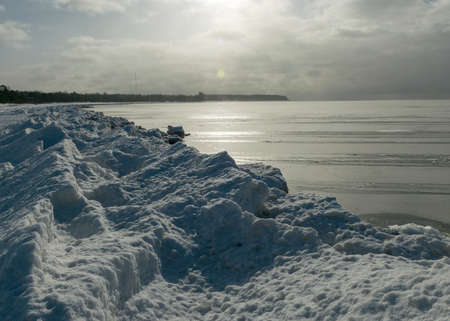 winter landscape by the sea, snowy pieces of ice by the sea and ice texture at sea, dunes covered with a layer of white snowの写真素材