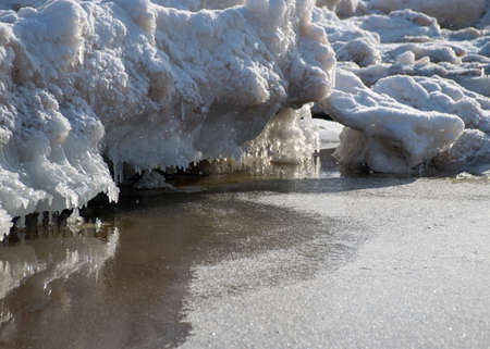 winter landscape by the sea, snowy, interesting ice shapes on the sea shore, dunes covered with a white layer of shining snow, winterの写真素材