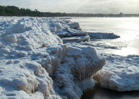 winter landscape by the sea, snowy, interesting ice shapes on the sea shore, dunes covered with a white layer of shining snow, winterの写真素材