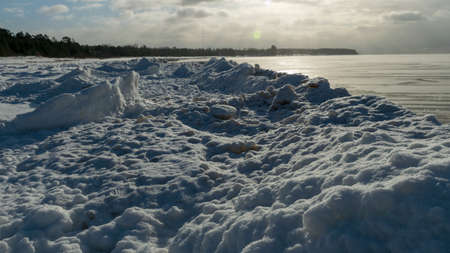 winter landscape by the sea, snowy pieces of ice by the sea, dunes covered with a white layer of shining snow, winterの写真素材
