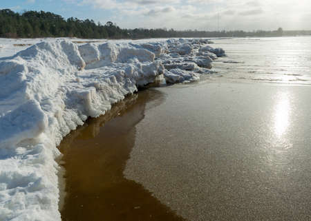 winter landscape by the sea, snowy, interesting ice shapes on the sea shore, dunes covered with a white layer of shining snow, winterの写真素材