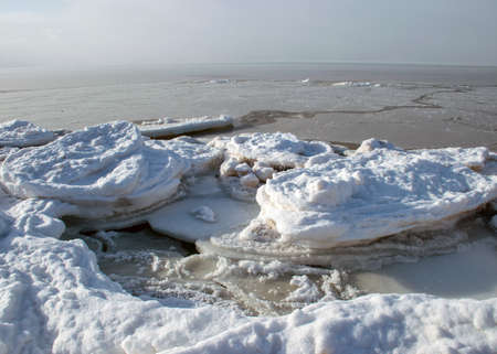 winter landscape by the sea, snowy, interesting ice shapes on the sea shore, dunes covered with a white layer of shining snow, winterの写真素材