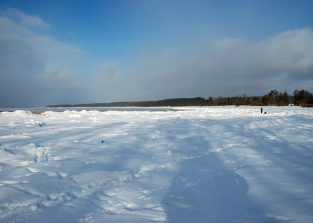 beautiful winter landscape with footprints in the snow, white snow covered dunes, seashore, winter dayの写真素材