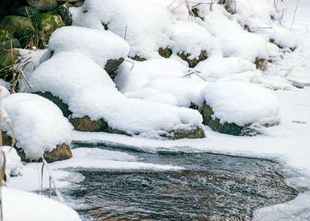 icy and snowy rocks on the river bank, winter backgroundの写真素材