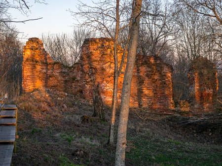 Ruined brick wall of a medieval castle, beautiful sunset colors in spring, Augstroze Castle Mound, Latviaの写真素材