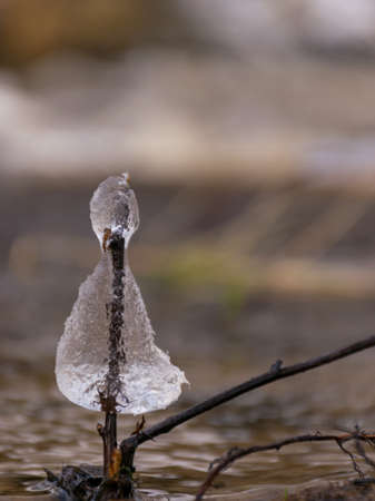 picture with various ice formations against a background of a fast flowing blurred riverの写真素材