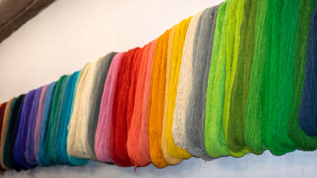 wool yarn threads, colored yarn skeins on the wall, knitting as a hobby, handicrafts are a good way...
