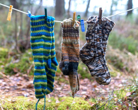 photography with knitted socks, socks hanging on a rope, handicraft concept, knitting as a hobby, handicrafts are a good way to spend free timeの写真素材