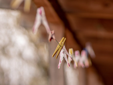 clothes pegs on clothesline, blurred background of wooden boards, close-up view