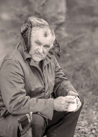 landscape with a forester in the woods by the fire, a worker drinks tea and warms up by the fire,...